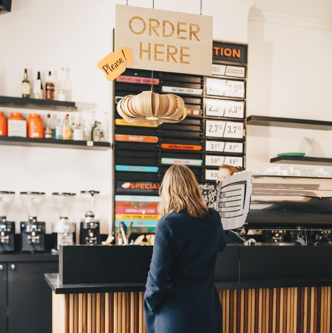 Customer ordering coffee at a modern coffee shop counter